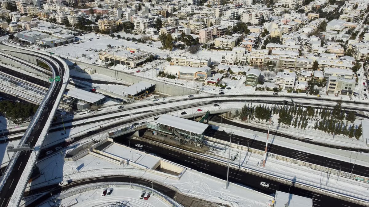 Aerial view of Athens city with snow-covered roads and buildings in winter.